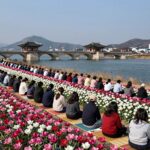 밀양 어화꽃불놀이 명당에서 바라본 영남루와 응천강 야경, 사람들이 돗자리에 앉아 기다리고 있음