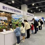 울산119안전문화축제 여름 가볼 만한 곳 울산119안전문화축제 실내 전경으로 다양한 체험 부스가 설치되어 있고 가족 단위 방문객들이 줄을 서서 기다리는 모습
